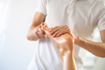 Professional masseur doing therapeutic massage. Woman enjoying massage in her home. Young woman getting relaxing body massage.