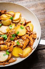 Roasted slices of young potatoes with chanterelle mushrooms. Selective focus. Shallow depth of field.
