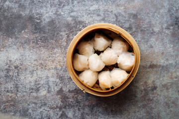 Asian steamed dish. Dim sum on a food shelves, various Chinese steamed dumpling in bamboo basket steamer in Chinese restaurants. with a chopstick