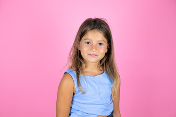 Young beautiful child girl over isolated pink background smiling and looking at the camera