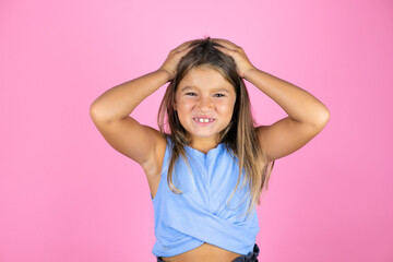 Young beautiful child girl over isolated pink background suffering from headache desperate and stressed because pain and migraine with her hands on head