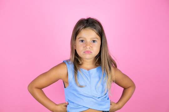 Young Beautiful Child Girl Over Isolated Pink Background Skeptic And Nervous, Disapproving Expression On Face With Arms In Waist