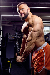 Fototapeta na wymiar Handsome male bodybuilder in gym. Big strong man during training in the gym. Guy with big muscles who is an athlete, trainer or instructor