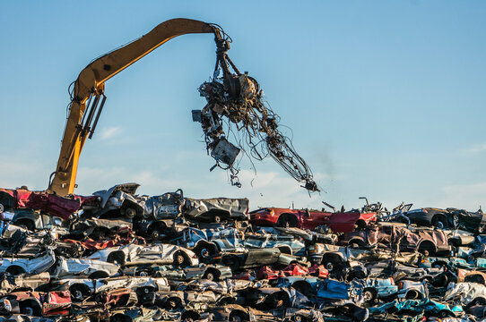 Excavators stacking cars for scrap.