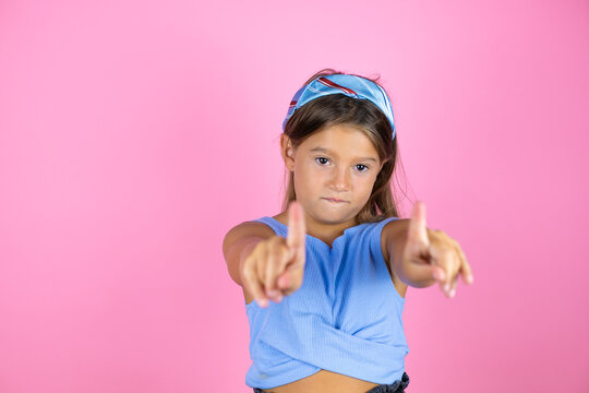 Young beautiful child girl over isolated pink background saying no with fingers, angry and frustration expression