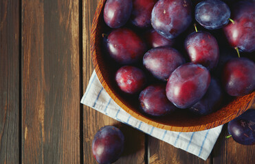 fresh plums on wooden surface