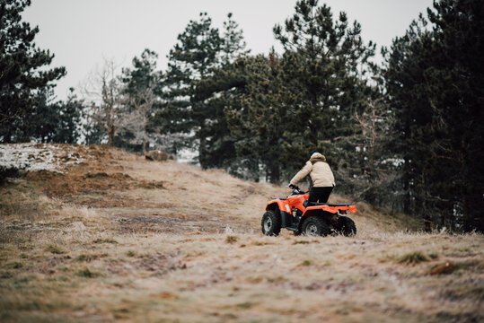 Adult man driving a quadro motorcycle on the mountain