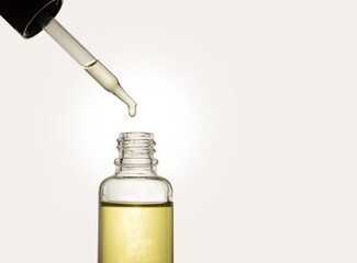 Pipette with cosmetic oil on a light background. A bottle of cosmetics. Skin, hair, and body care....