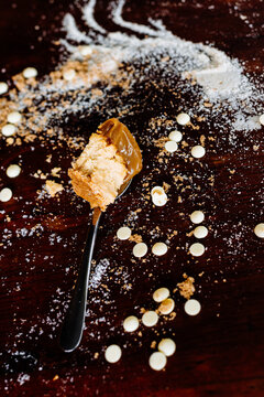 spoonful of salted caramel cheesecake with ingredients, on a woo