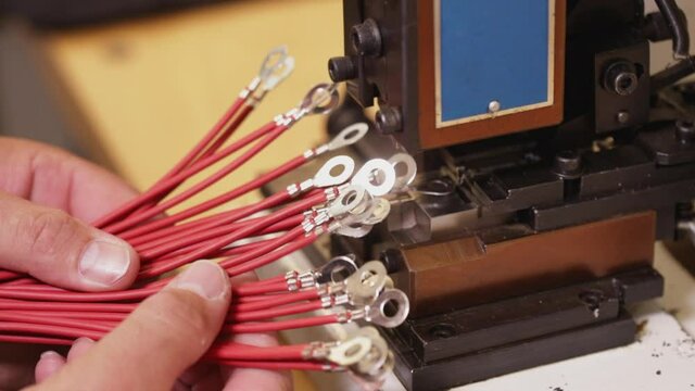 Hand examine electric wire connector terminals applied with a crimping machine - close up, static camera