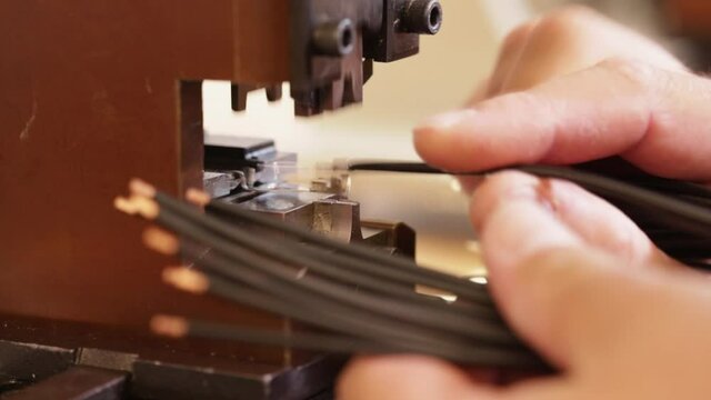 Hand apply wire connector terminals to electric wires using a crimping machine - close up, static camera