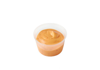 spicy sauce in a plastic container on an isolated white background
