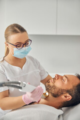 Fototapeta premium Female esthetician performing laser hair removal procedure