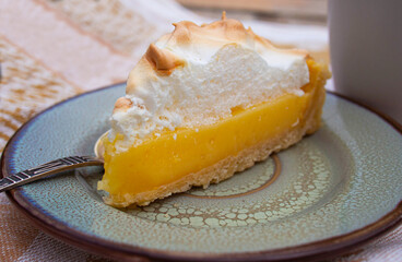 Lemon meringue pie on a rustic saucer