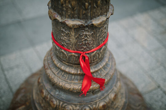 Red ribbon tied around a Paris lamppost