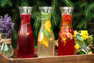 Three fruit and berry lemonades on the wooden tray