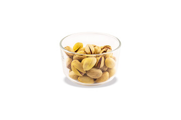 Pistachios in glass transparent bowl. Close-up. Isolated on white background.