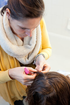 Mother looks through her 10 year old daughter's hair for lice or nits