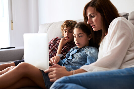 Family using laptop on couch.