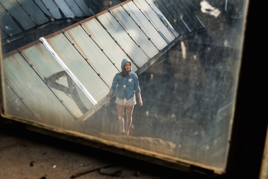 Woman stands on a roof of an old industrial building