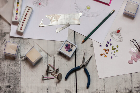 Jeweler's tools and gemstones on the white board