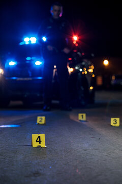 Shell casings are marked with evidence tags at a crime scene