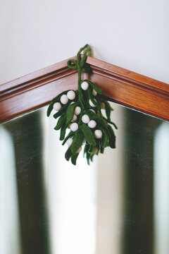 Cute felt mistletoe decoration hang from ancient mirror