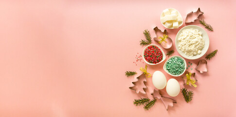 Ingredients for baking christmas cookies. Eggs, flour, sugar and sweet sprinkles on a pink background with copy space