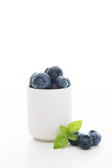 Fresh summer blueberry in a white Cup isolated on a white background