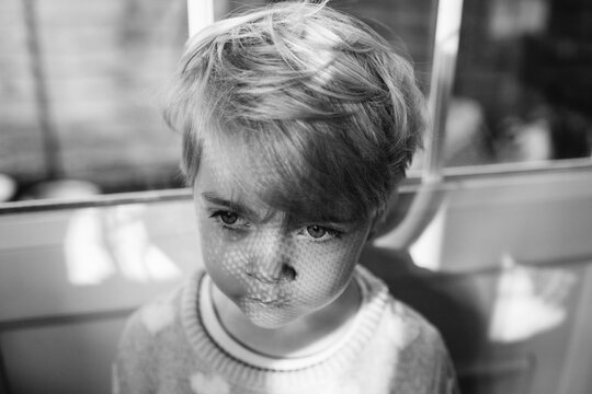 Serious child with interesting shadows across her face.