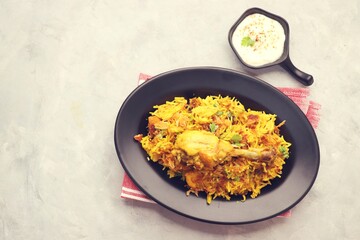 Chicken Biryani/murg Pulao.  Garnished with fried onion & chopped coriander. Biryani raita is a famous Spicy non vegetarian dish of India. Chicken cooked along with Basmati rice & spices. copy space.
