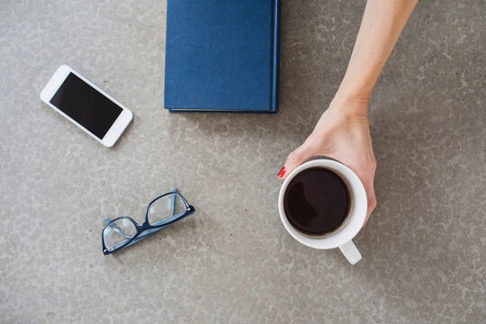 Female hand taking a cup of coffee