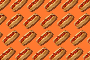 Delicious fast food for lunch in menu. Hot dogs with bun, sausage and red ketchup on orange background