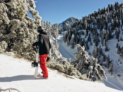 Male Snowboarder Overlooking Empty Ski Slope