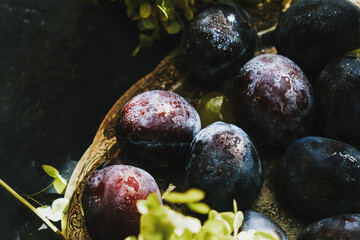 Fresh ripe plums on silver platter.