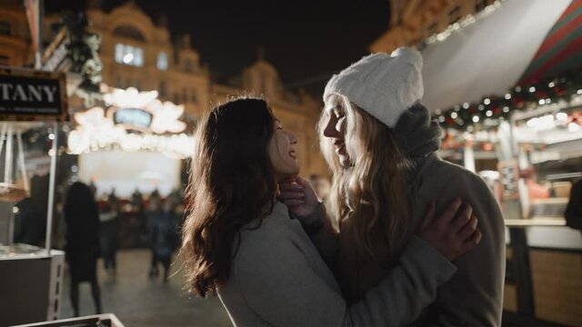 Lesbian girls in love at xmas time. Night prague old town square. Pride, lgbt, love, friendship, christmas, holiday, vacation concept. Filmed on RED camera, 10 bit clolor