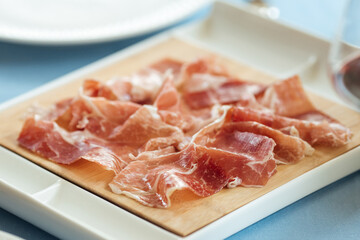 Spanish sliced pork jamon on the white plate 