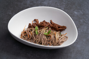 Thai soba salad in white bowl. Stir fry noodles, Soba salad with vegetables and meat.