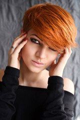 Portrait of a beautiful young red-haired woman with short hair