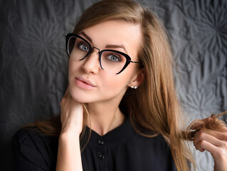 Portrait of a beautiful young woman wearing elegant glasses. Optics style