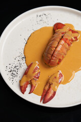 Seafood lobster with soup sauce. Cooked lobster on restaurant table, close-up