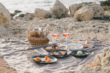 Romantic brunch picnic with champagne and fresh homemade food near sea