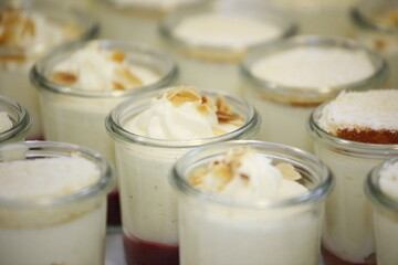 Viele Dessert Gläser mit Nachtisch und Dekoration.