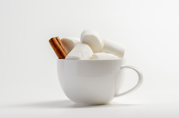 Cup of cocoa with marshmallows, cinnamon on white background.