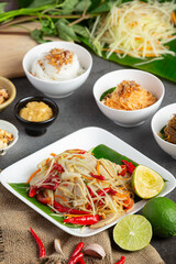 Papaya salad served with rice noodles and vegetable salad Decorated with Thai food ingredients.