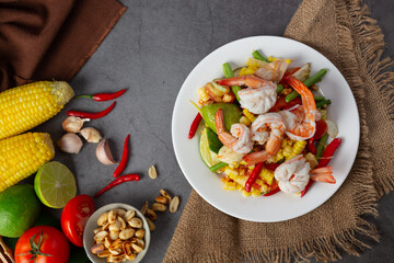 Som Tum with Corn and Shrimp, served with rice noodles and green salad Decorated with Thai food ingredients.