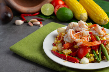 Som Tum with Corn and Shrimp, served with rice noodles and green salad Decorated with Thai food ingredients.