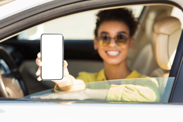 Smiling Woman Showing Phone With Empty Screen Sitting In Auto