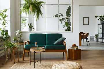 Stylish scandinavian living room interior with green velvet sofa, coffee table, carpet, plants,...