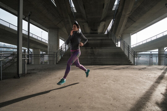 Sportswoman Running Under The Bridge